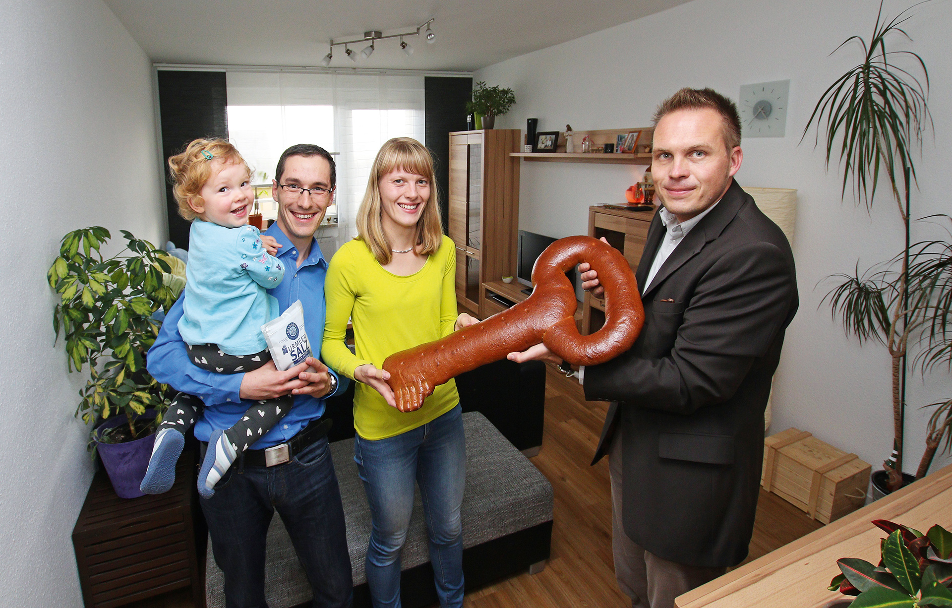 Michael Wied (rechts) übergab einen symbolischen Wohnungsschlüssel aus Brotteig an Marcel Kämpf, Stephanie Uhlich und Tochter Mia.